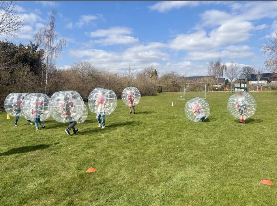Barn spelar bumperball på gräsplan