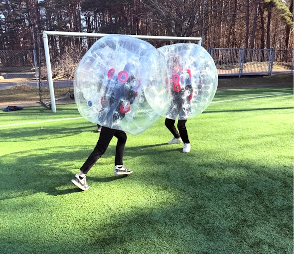 Barn springer i bumperballs på konstgräs